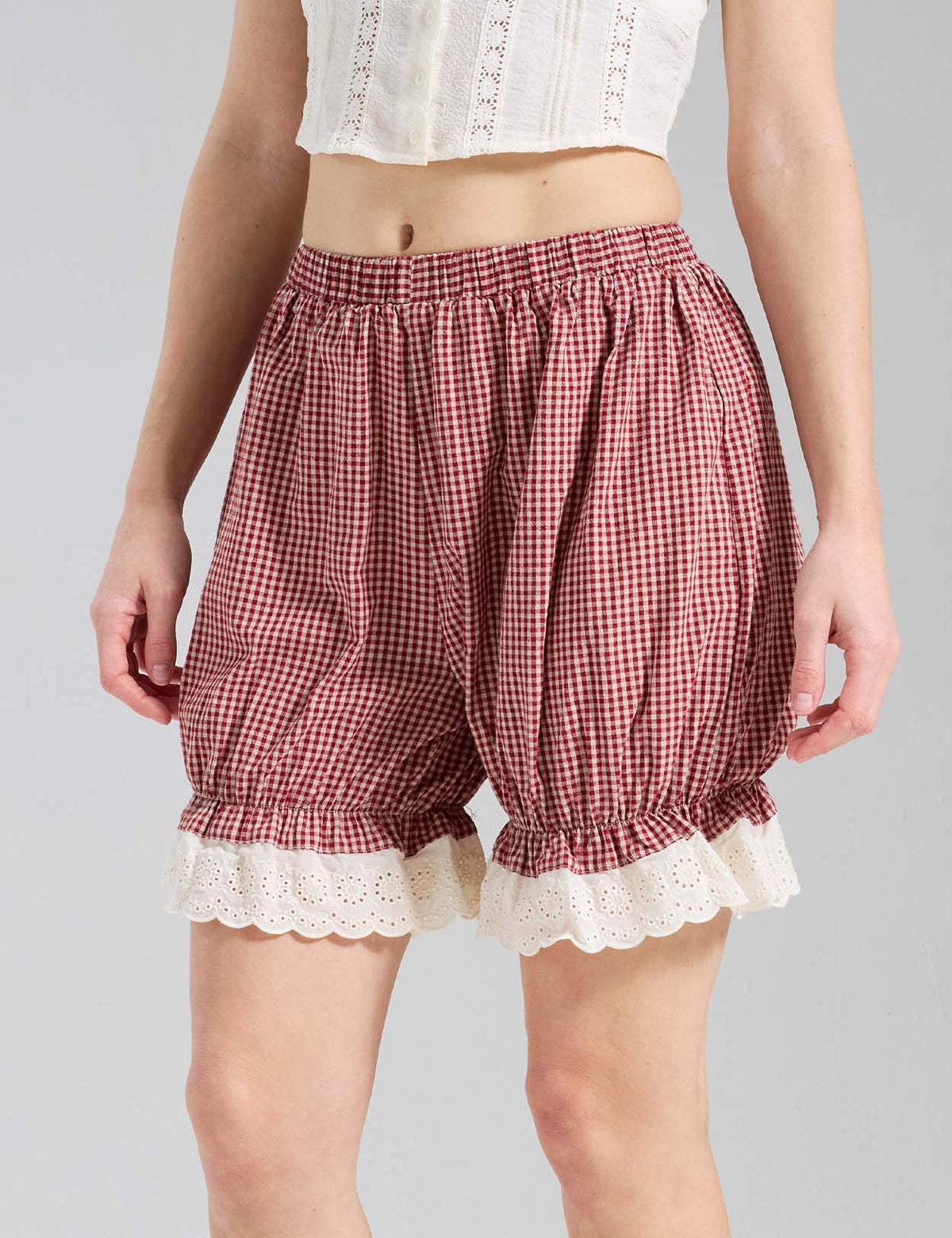 Close-up of Beautelicate Vintage Red Gingham pumpkin pants showing eyelet lace cuff and elastic waistband detail