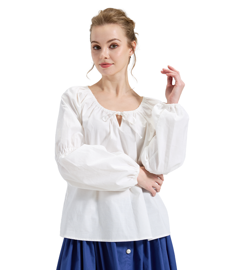 Woman modeling an ivory Victorian chemise blouse with shirred cuffs, posing with one arm gracefully raised.