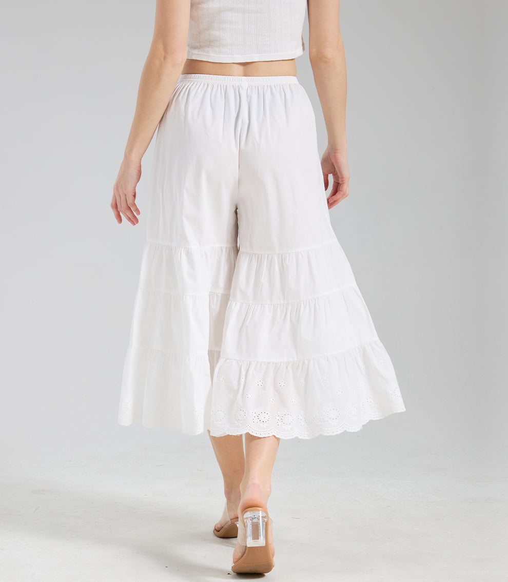 Back perspective of ivory layered culottes with subtle movement in the ruffles and eyelet lace trim.