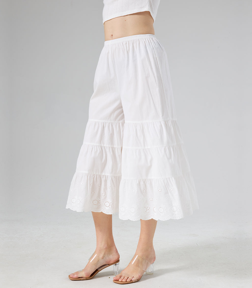 Side profile of ivory tiered culottes showing the elegant drape of the fabric and ruffles.