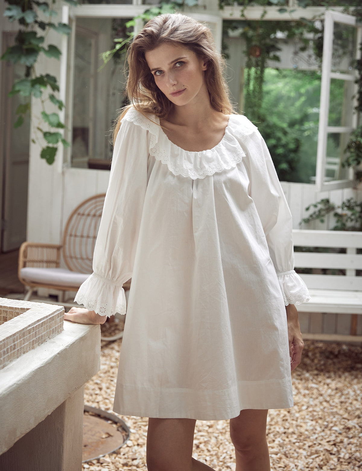 Close-up detail of embroidered ruffles and bell sleeves on Victorian cotton nightdress showing intricate craftsmanship
