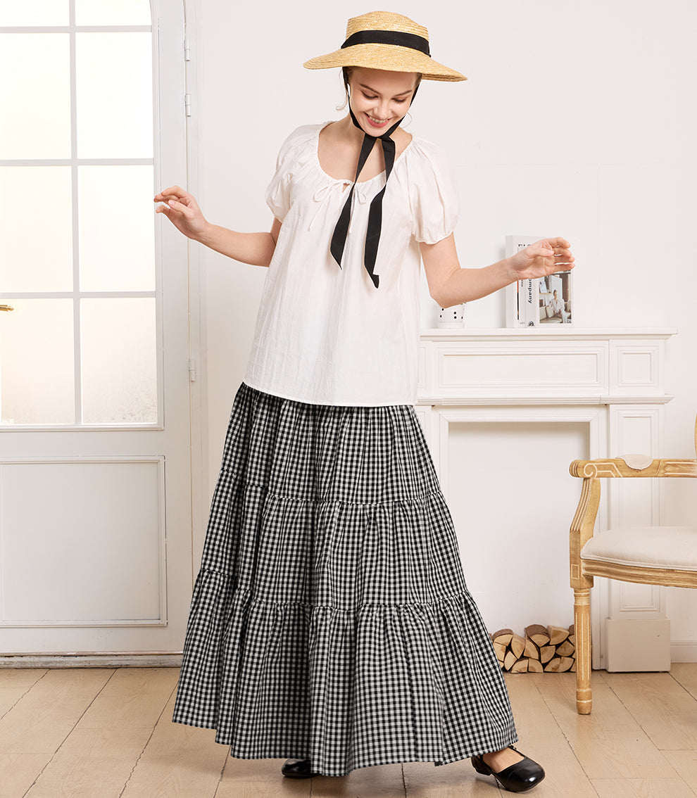 ifestyle shot of a model wearing the boho vintage plaid cotton maxi skirt with side pockets, paired with a white blouse and straw hat.
