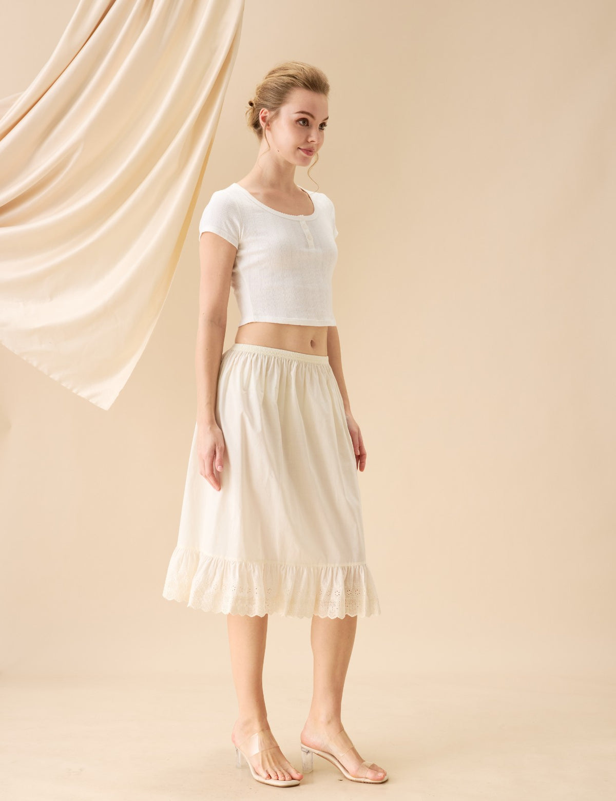 Full length view of a vintage cream cotton half slip with ruffle hem.