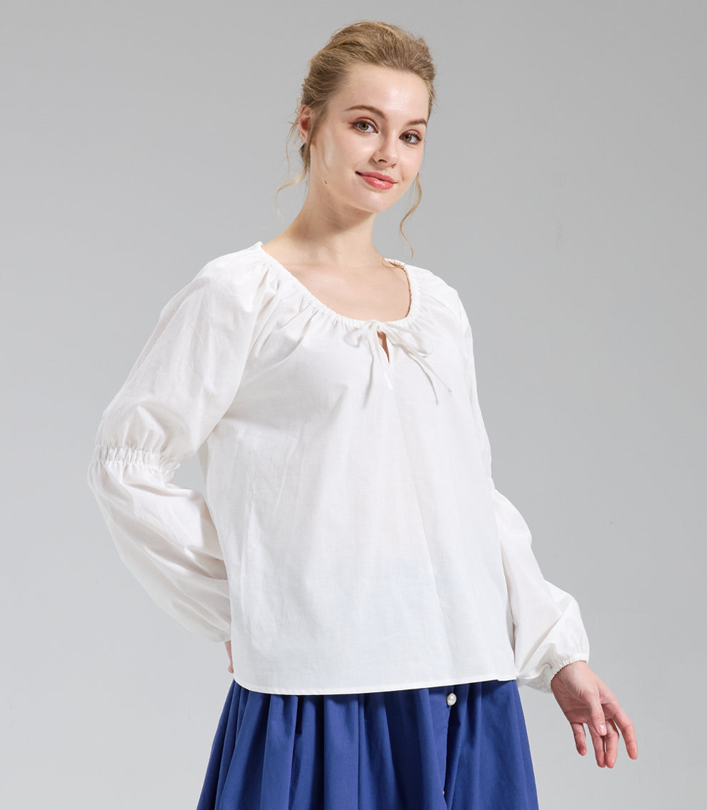 Classic ivory pirate shirt showing a flowy fit falling from a gathered neckline, modeled with arms positioned slightly back.