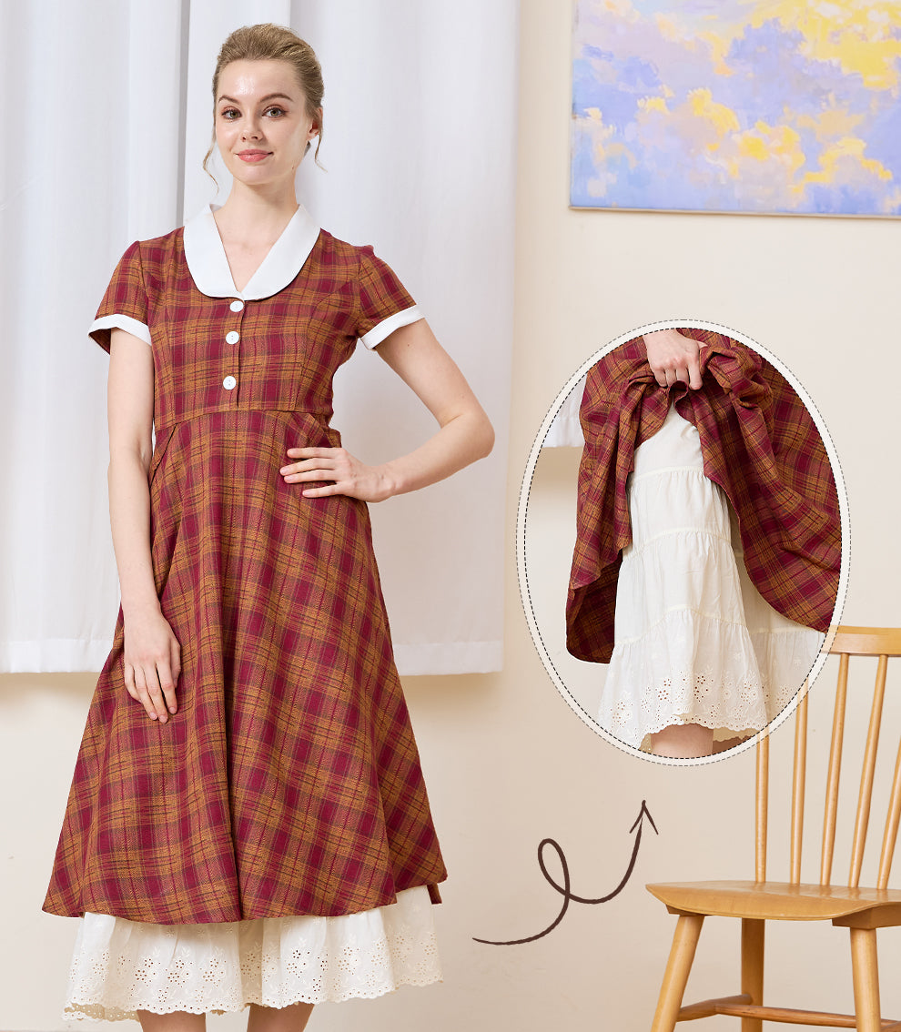 Cream bloomers styled as an underskirt extender beneath a plaid dress to showcase the decorative layered lace hem.